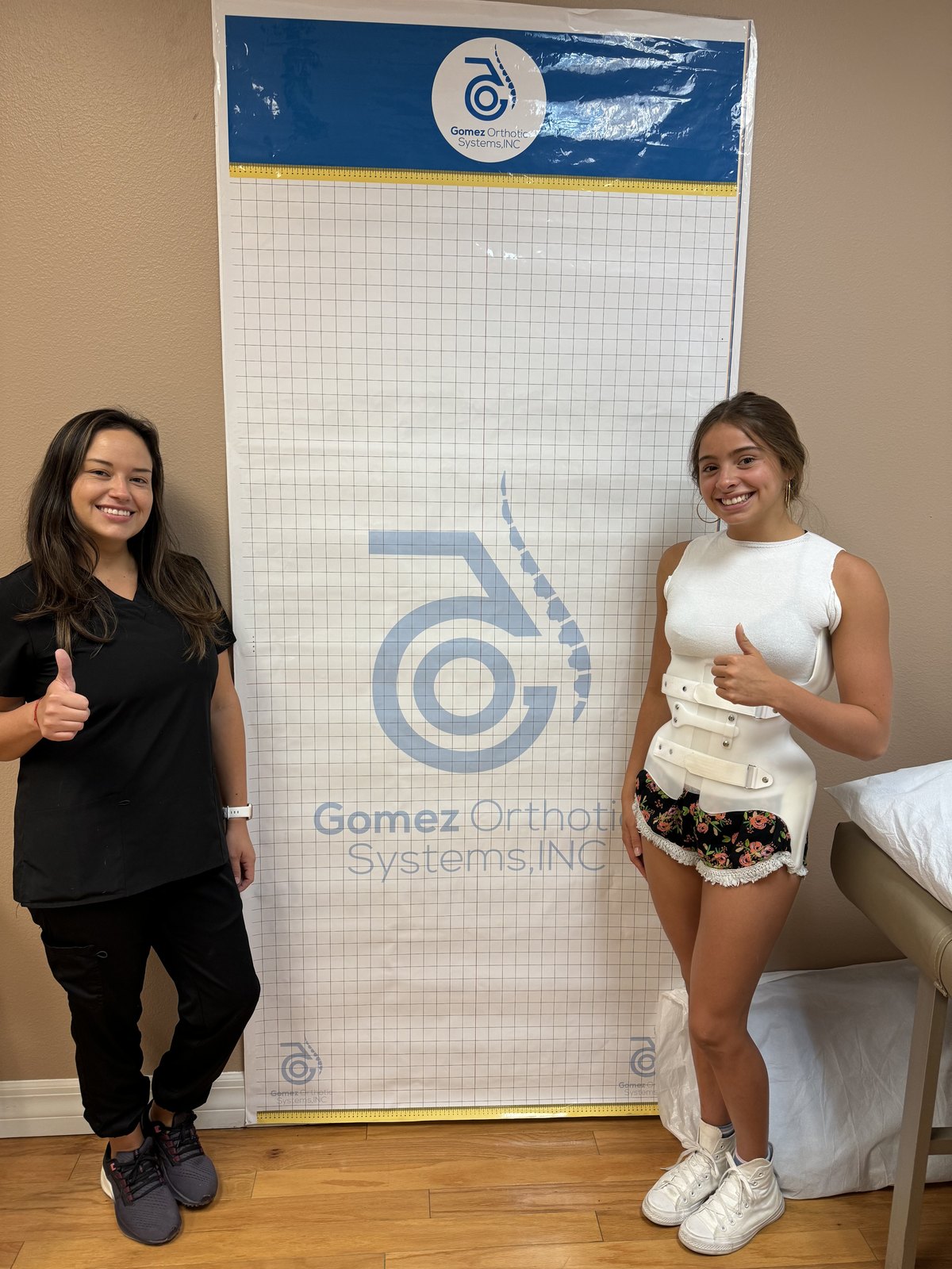 A Manifest clinician alongside a patient fitted in a custom GOSS spinal brace.