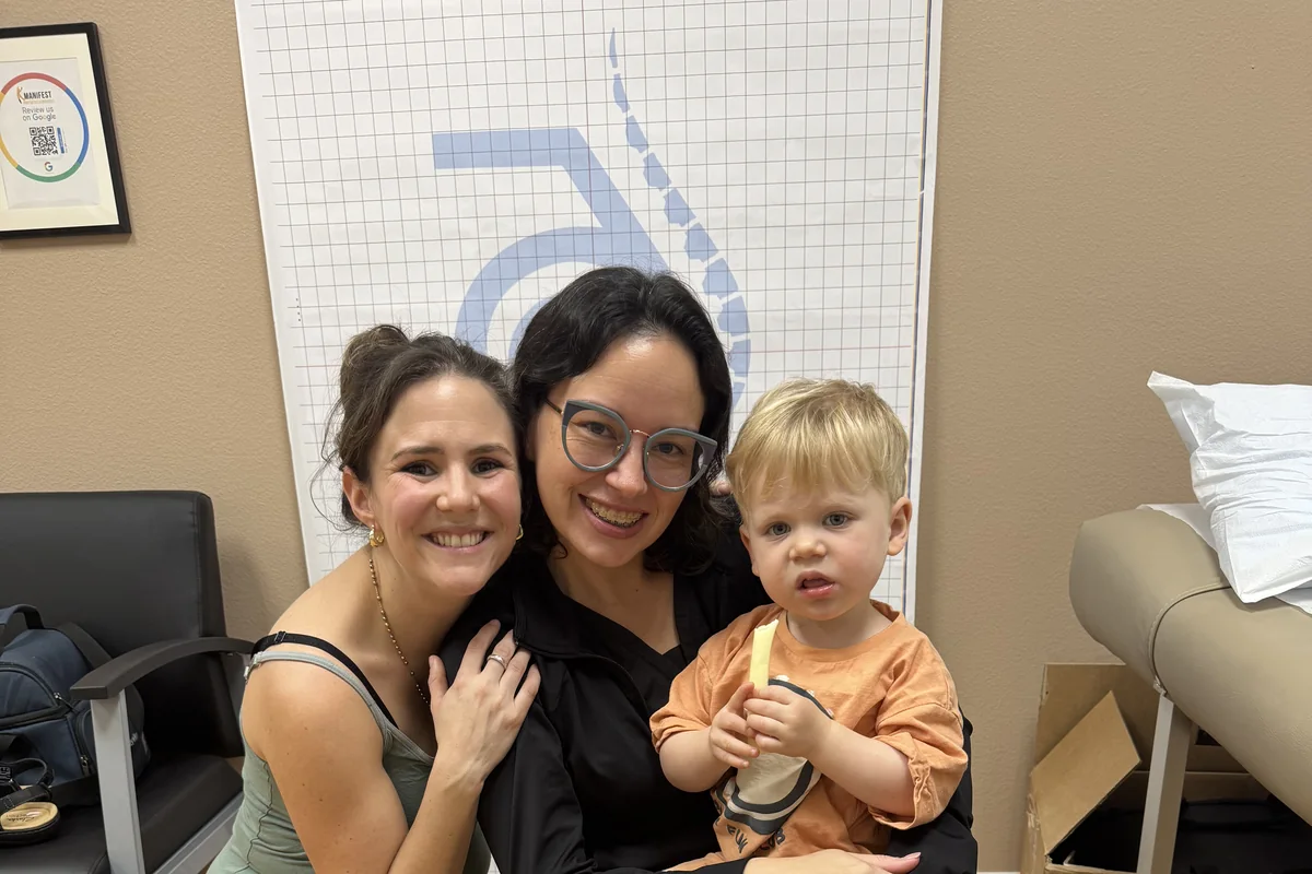 A Manifest clinician with a young patient and their mother in the clinic.
